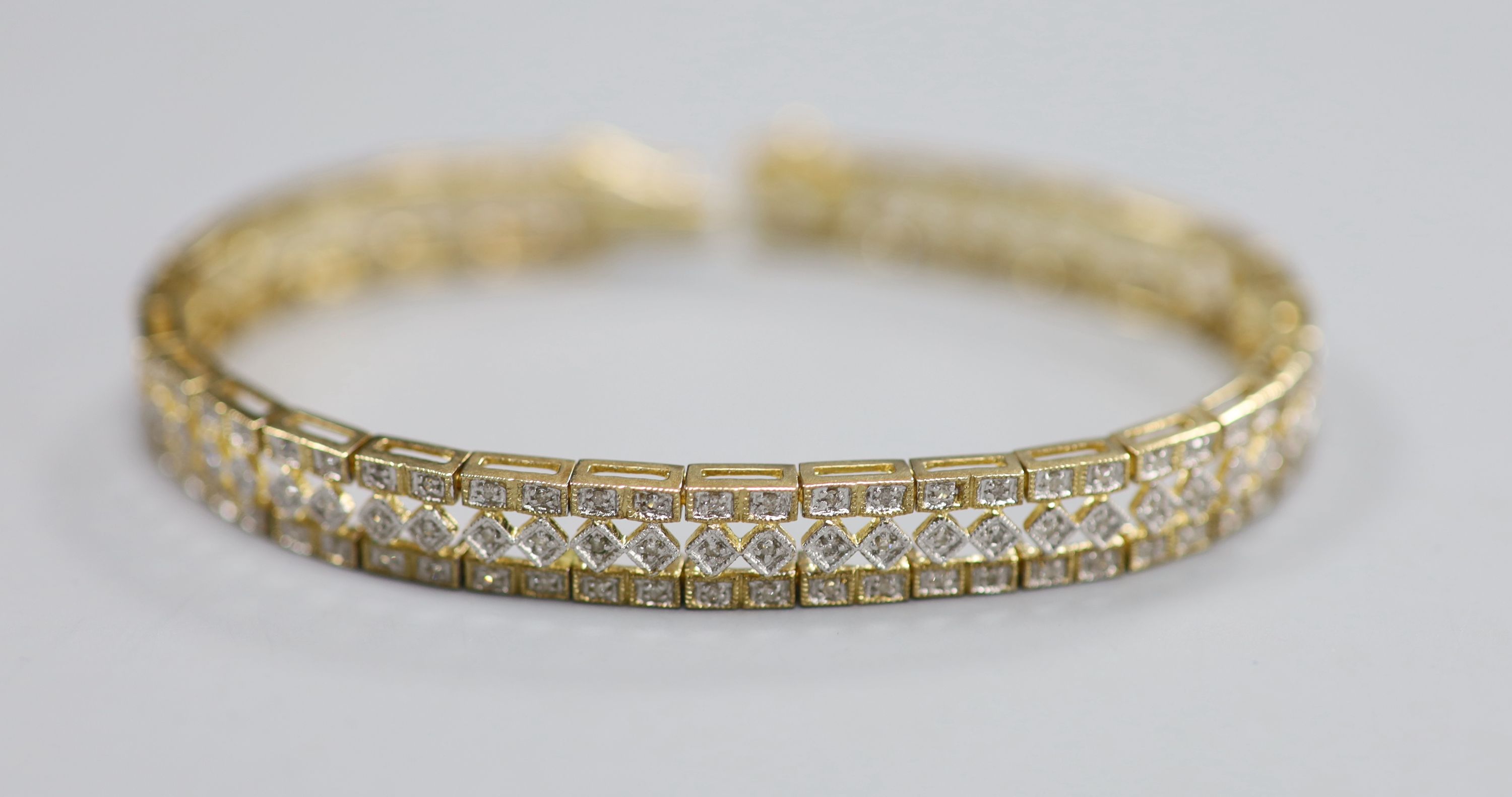 A modern pierced 9ct gold and diamond chip set line bracelet, length 18.5cm, gross 16.4 grams.